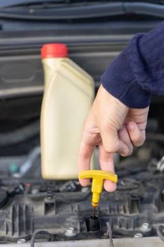 Hand of driver close-up holding engine oil dipstick. checking motor oil level Stock Photos