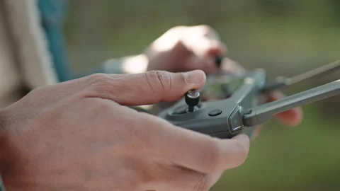 Hand of a Drone Operator man while pilot a quadcopter remote controller. Stock Footage 180556202