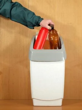 Hand, dropped two plastic bottles in the trash for disposal. Stock Photos