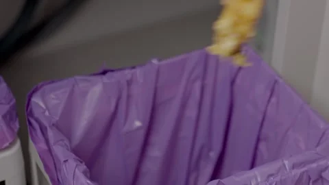 Hand dropping apple core into trash bin in kitchen Stock Footage 327986181