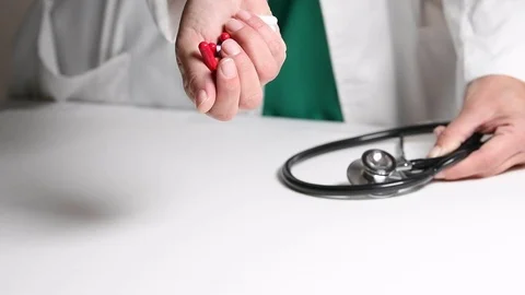 Hand dropping assorted pills on a table Stock Footage 122410877