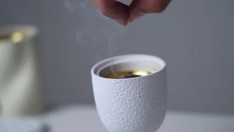 Hand dropping bakhoor wood into ceramic incense burner Stock-Footage 336763954