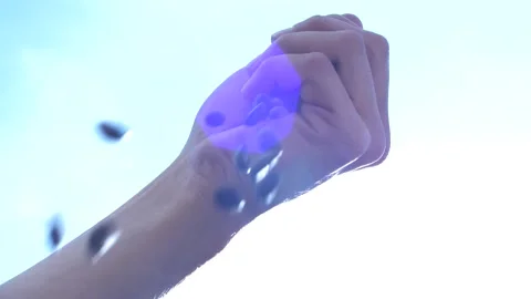 Hand dropping coffee beans in slow motion, background sky light Stock Footage 168994446