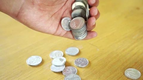 Hand dropping coins wealth and financial success amidst business recession. Stock Footage 322144508