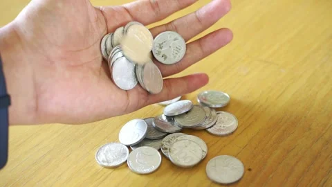 Hand dropping coins wealth and financial success amidst business recession Stock Footage 322144537