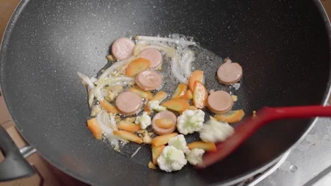 Hand Dropping Fresh sliced cauliflower into Hot Frying Pan with Oil. Capcay.. Stock Footage 329703930
