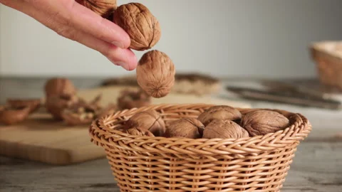 Hand dropping nuts into a basket in slow motion Stock Footage 152176221