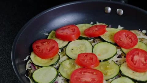 Hand Dropping Sliced Tomatoes into Pan Cooking Video stock 341456892