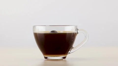 Hand Dropping Sugar Cube into Glass Mug of Black Coffee Stock Footage 341837086