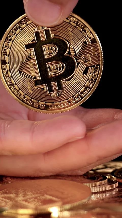 Hand Drops Bitcoin Token Onto Stack of Cryptocurrency Coins Stock Footage 316734082