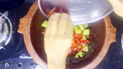 Hand drops diced vegetables into sizzling spices Stock Footage 313667871