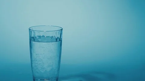Hand drops a effervescent pill that dissolves in a glass of water Stock Footage 71575497