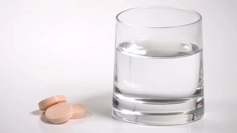 Hand drops an effervescent tablet in a glass of water Stock Footage 91172638