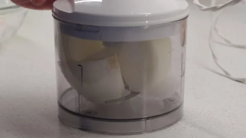 Hand Drops Onion Into Plastic Blender Bowl with A Solid Thud Stock Footage 321526868