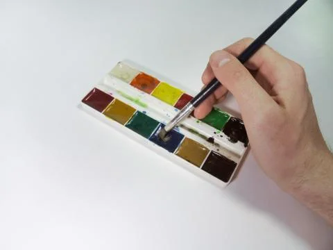 Hand, dunking the brush into the paint Stock Photos