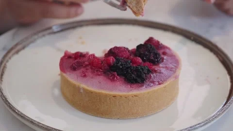 Hand Eating Berry Tart With Fork And Knife On Ceramic Plate In Café Setting Stock-Footage 343228440