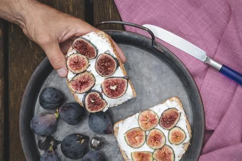 Hand eating ricotta sandwich with fresh figs Stock Photos