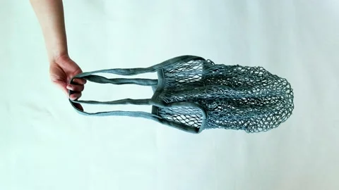 Hand with eco friendly string bag on white background Video stock 209126398