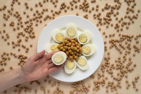 Hand with an egg above the dish Stock Photos