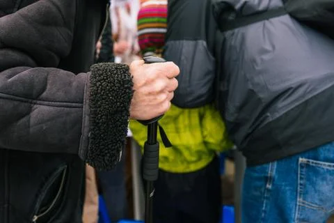 The hand of an elderly man with a cane. An old man leans on a stick. Beggar p Stock Photos