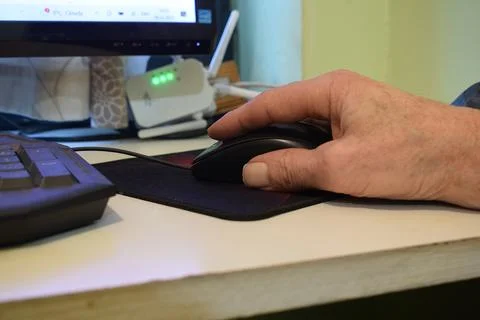 Hand of an elderly man with a computer mouse.. Stock Photos