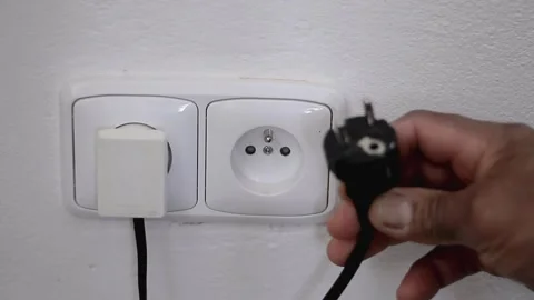 Hand with electric plug plugged into a normal socket stock video Stock Footage 149206046