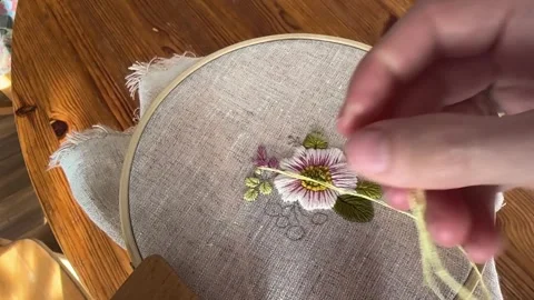 Hand embroidery stitching process on wooden table, cozy slow living craft Stock Footage 334375883