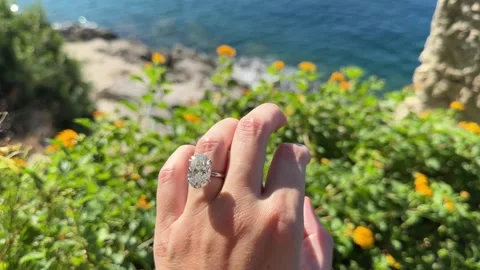 Hand with engagement ring above clear turquoise Adriatic water Stock Footage 319693767