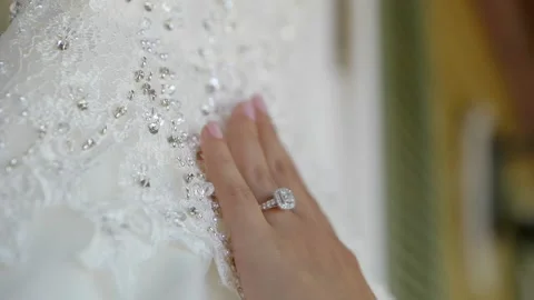 Hand with engagement ring slowly moving down wedding dress Stock Footage 160072801