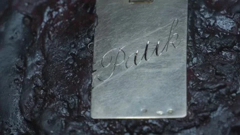 Hand engraving elegant cursive script letters into gold jewelry pendant closeup Video stock 323313969