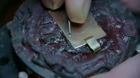 Hand engraving elegant cursive script letters into gold jewelry pendant closeup Stock-Footage 323383236