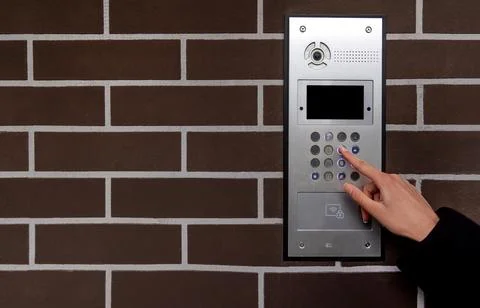 Hand entering code on keypad at building entrance. Space for text. Stock Photos