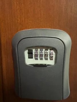 Hand entering code on outdoor key lock box. Close-up of a person inputting .. 写真素材