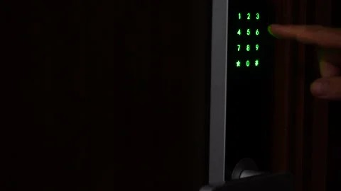 Hand entering unlocking combination on digital security lock and opens a door Stock Footage 136416670