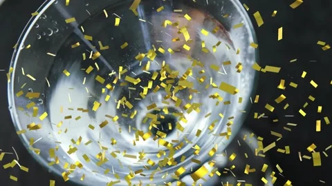 Hand entering upper right stirring glass, forming vortex bubbles, olive Stock Footage 321889436