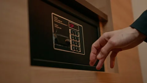 A hand enters a code to open and lock a safe or safe in a hotel room Theft or Stock Footage 237892578