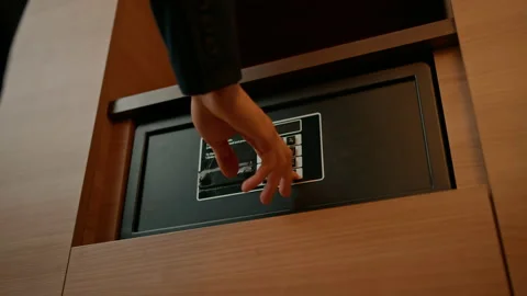 A hand enters a code to open and lock a safe or safe in a hotel room Theft or Stock Footage 237892675