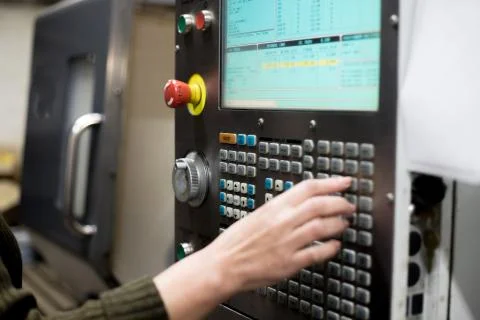 The hand enters data on the control panel of the lathe Stock Photos