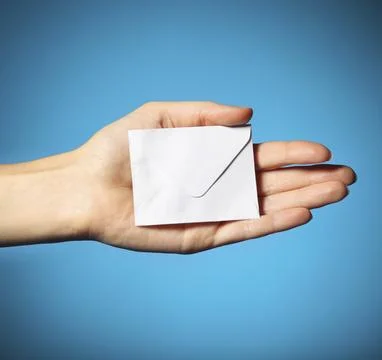Hand with the envelope against the blue background Stock Photos