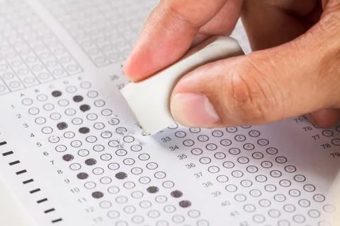 Hand erase wrong answer on  exam carbon paper computer sheet Stock Photos