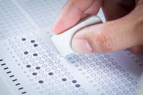 Hand erase wrong answer on  exam carbon paper computer sheet Stock Photos