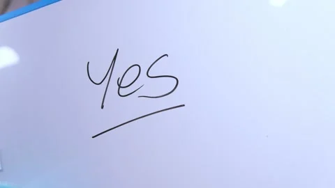 Hand erasing the word yes from a whiteboard Stock Footage 325990795