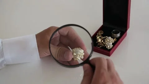 Hand Examining Rings And Earrings With Magnifier Stock Footage 344912976