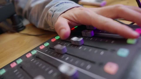 Hand expertly adjusting controls on a Podcast audio mixer or console. knobs Stock Footage 296307931