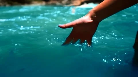 The hand falls into the blue mountain river Stock Footage 135404344