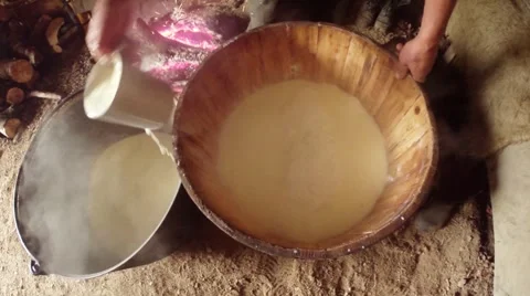 Hand of the farmer collects cup liquid whey from the wooden casks in cheese Stock Footage 43224692