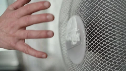 Hand feeling airflow from table fan Stock Footage 345661493