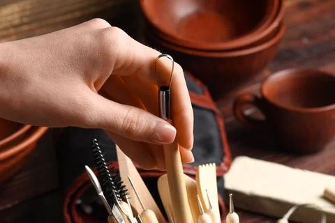 Hand of female sculptor taking loop tool from set of instruments, closeup Stock Photos