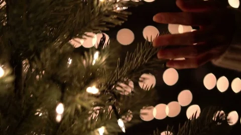 Hand female touching Christmas tree with bokeh lights in Christmas time Stock Footage 81482102