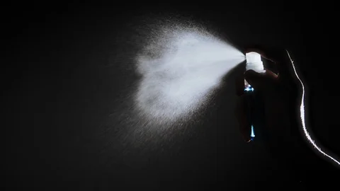 Hand female using alcohol spray on dark background Stock Footage 129223279